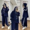 EaseFit Modest Tracksuit featuring a relaxed hooded top with white drawstrings and wide-leg trousers with side tie details, designed for modest comfort and sporty style, styled with a white inner hijab and sneakers in a soft indoor setting