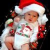 White baby romper with Santa Claus print and “Baby’s 1st Christmas” text — First Christmas Magic edition.